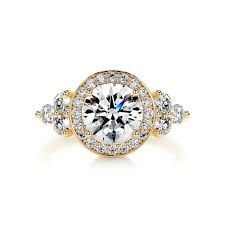 Gold ring with a large, clear center stone surrounded by a halo of smaller stones; three clusters of stones on either side.