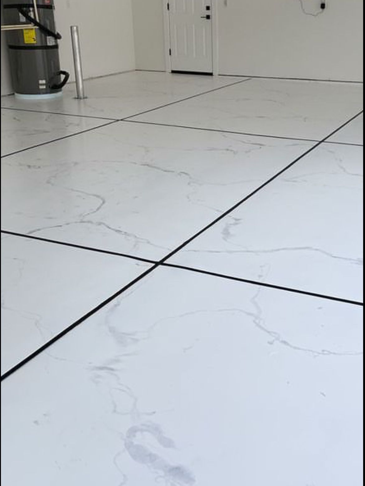 A white tile floor in a room with a vacuum cleaner