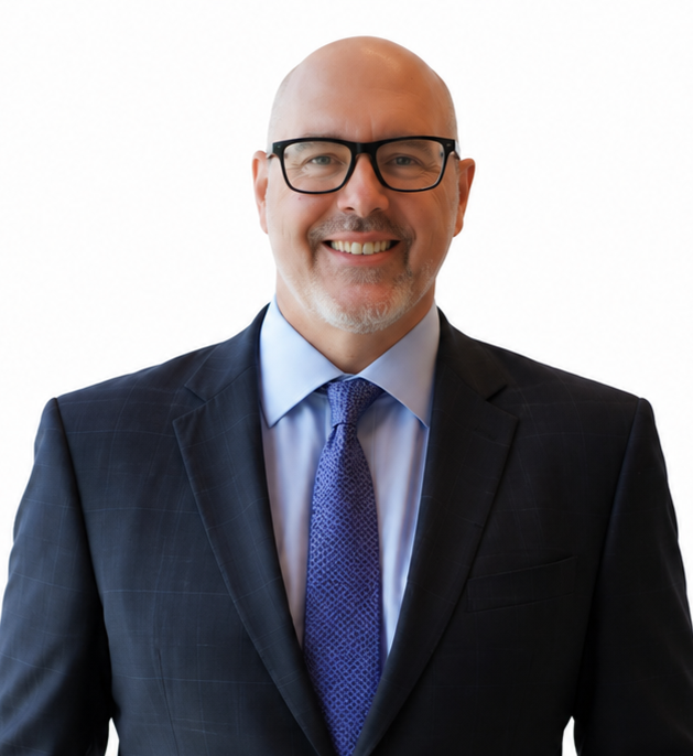 Smiling man in a dark suit, blue shirt, and tie on a white background
