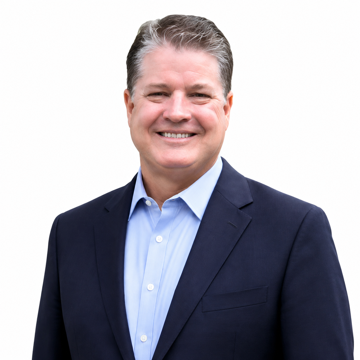Smiling man in a navy blazer and light blue shirt against a white background