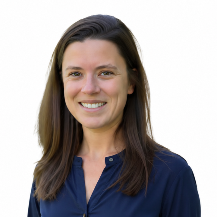 Portrait of a smiling person with long brown hair in a navy blue shirt against a white background