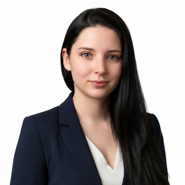 Professional headshot of a woman in a navy blazer with long dark hair on a white background
