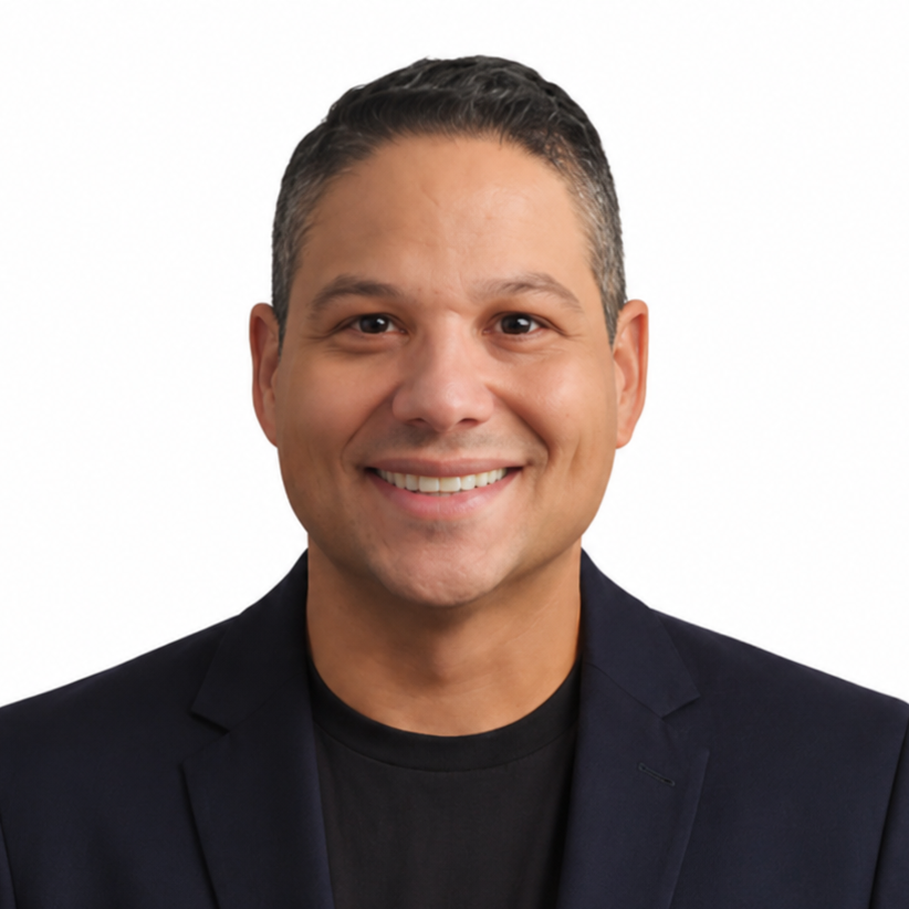 Smiling person in a dark blazer and black shirt against a white background