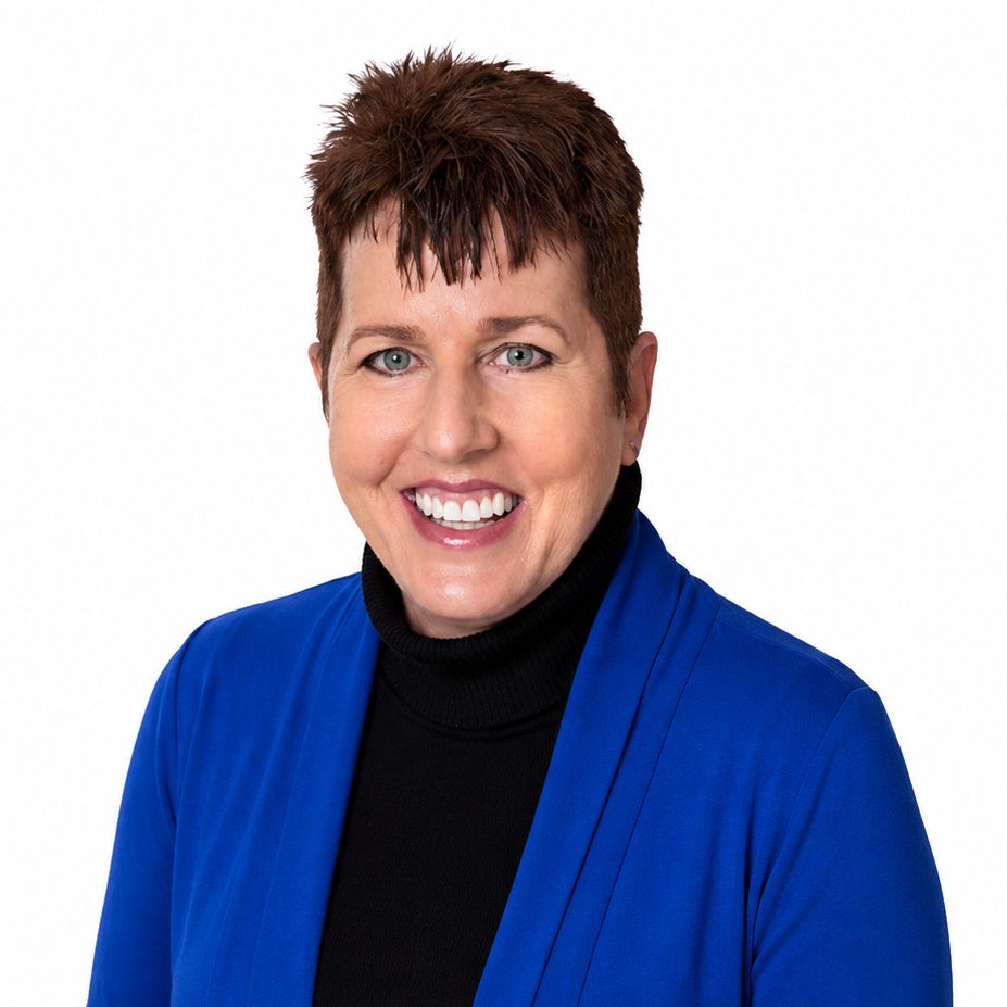 Portrait of a smiling person in a blue blazer and black turtleneck against a white background