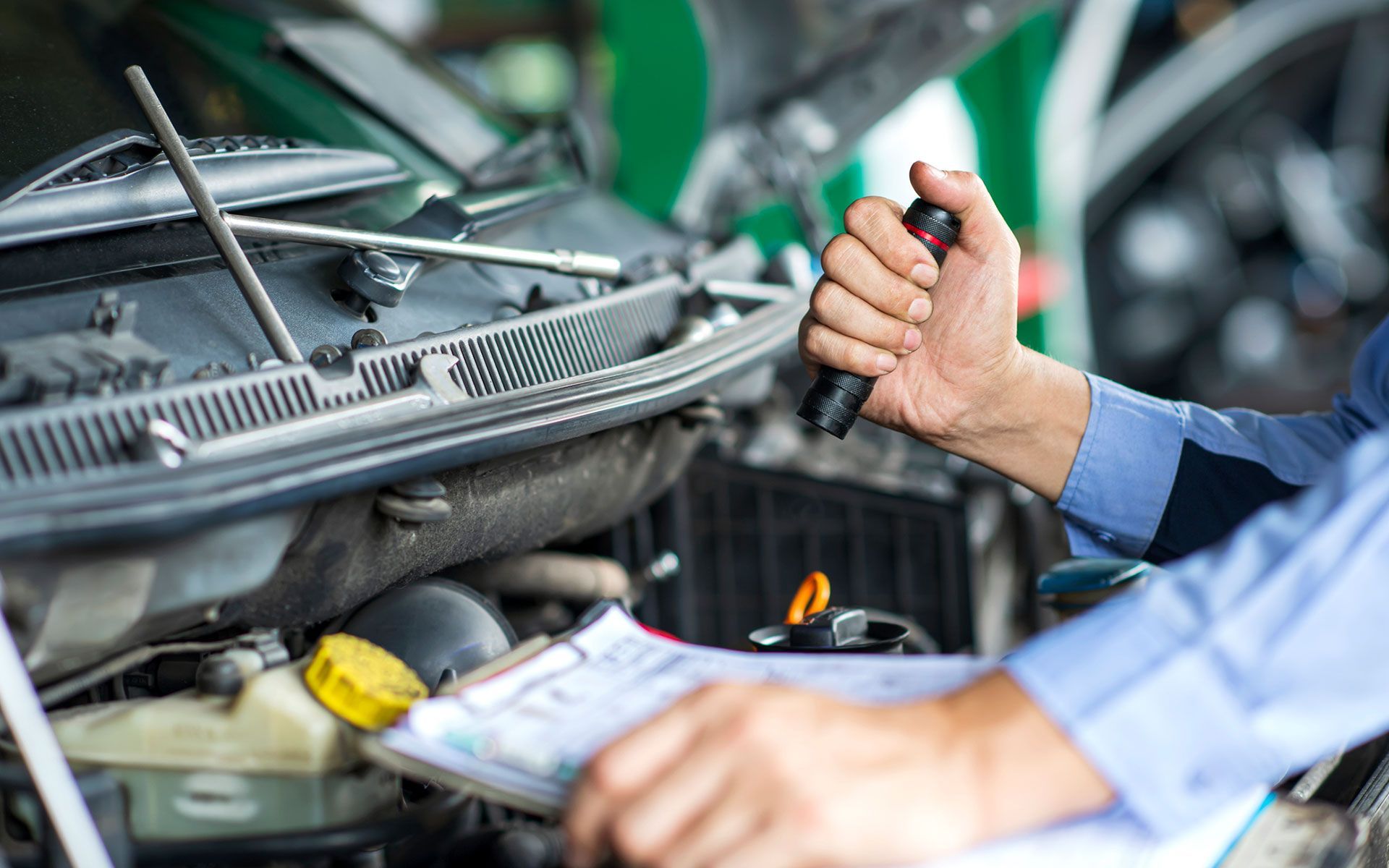 A mechanic is working on a car in a garage.
