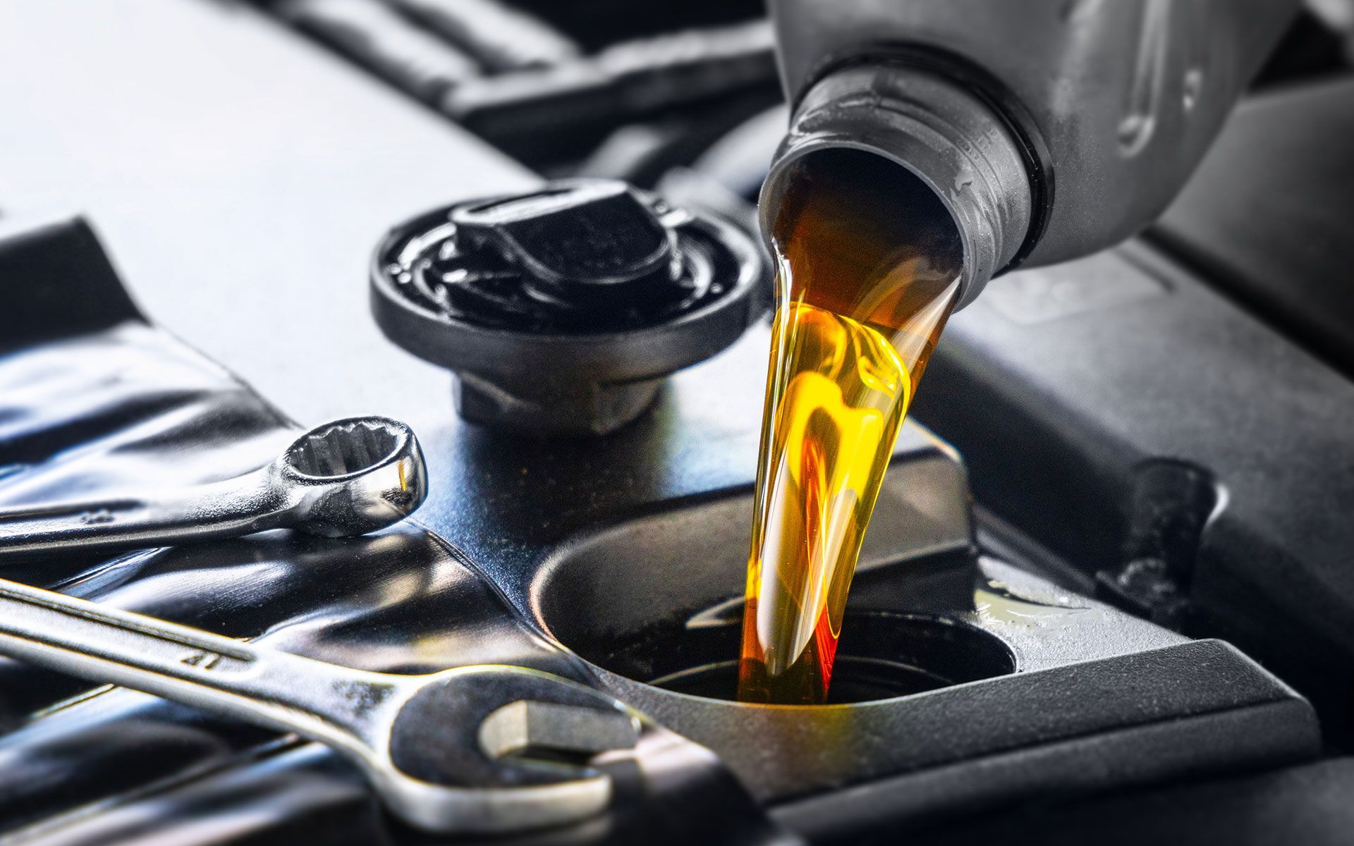 A bottle of oil is being poured into a car engine.