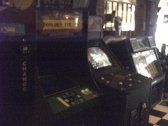 Two arcade game machines in a dark room; one labeled 