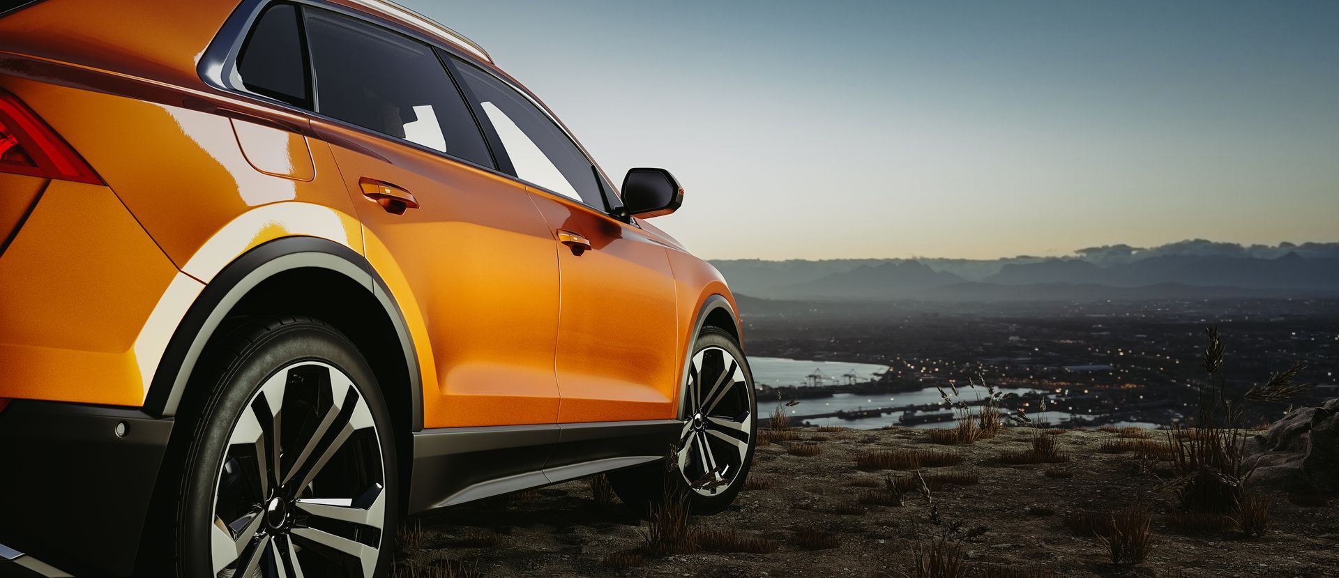 Orange SUV parked on a hilltop overlooking a city at dusk. | Rocky Mountain Car Care