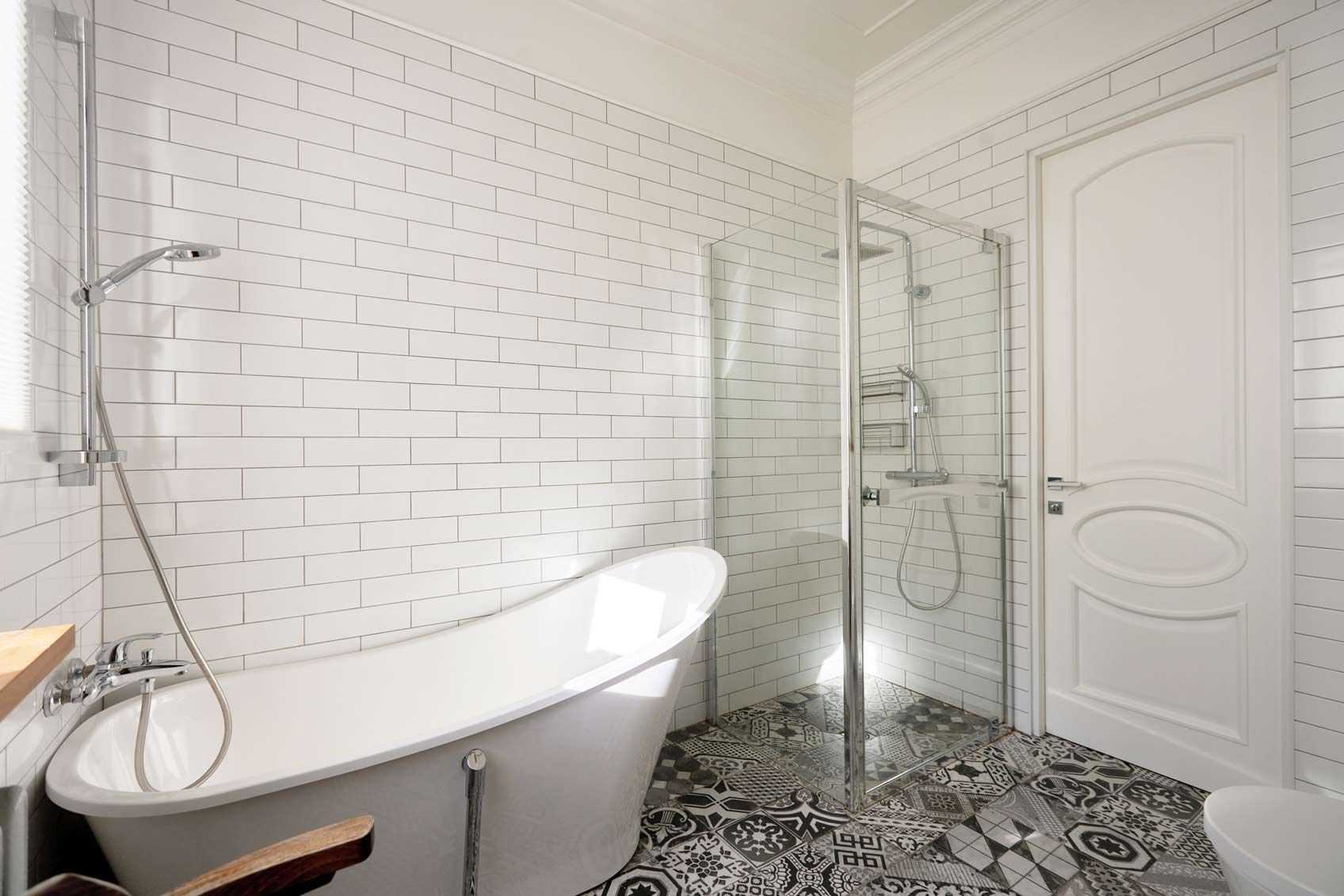 An elegant and modern bathroom featuring a luxurious freestanding bathtub along with a stylish shower space