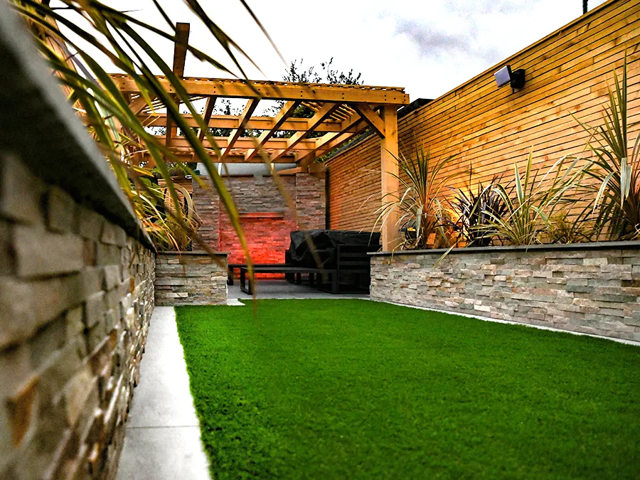 A garden with a pergola and a brick wall