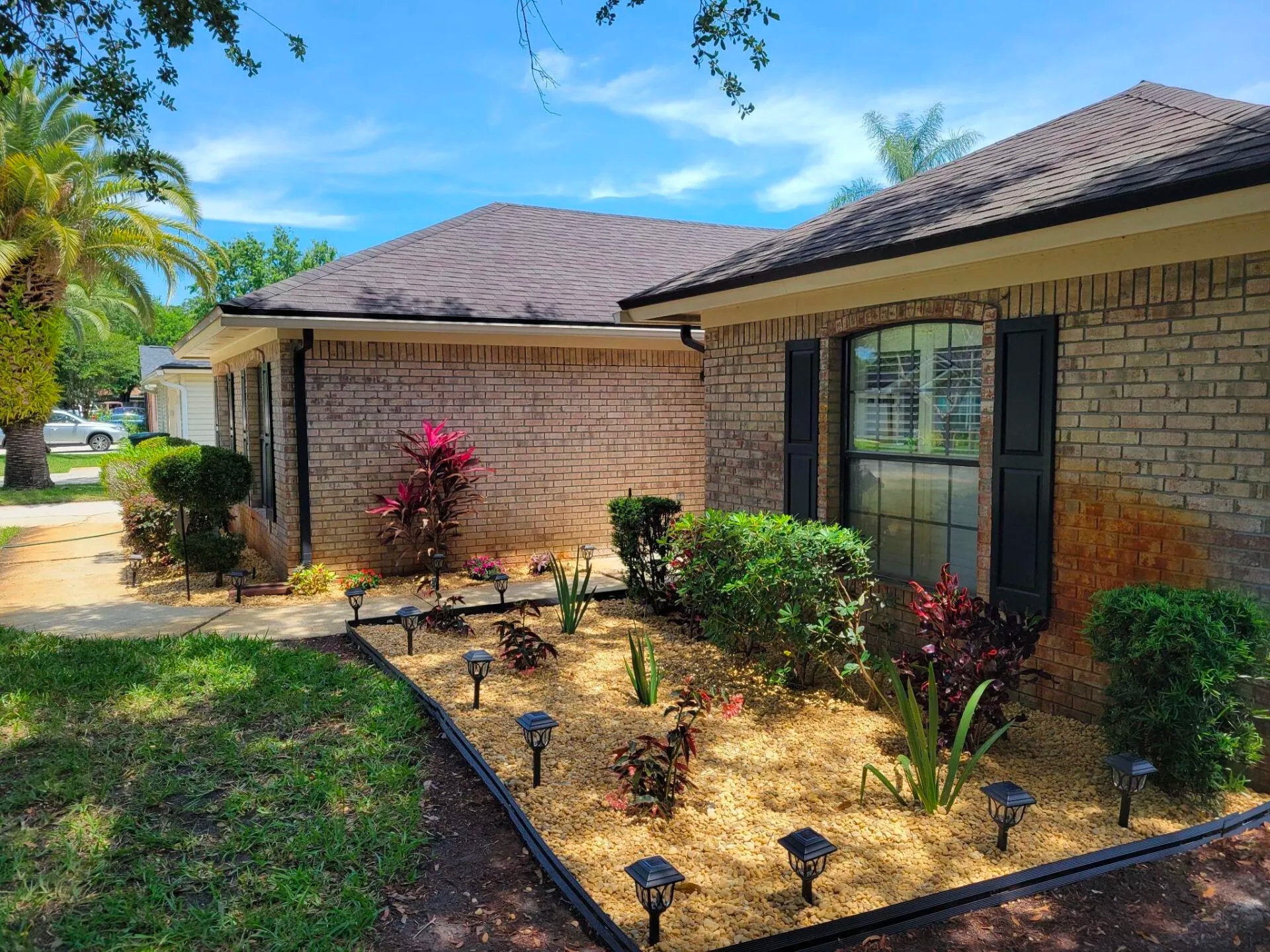 A brick house with a garden in front of it.