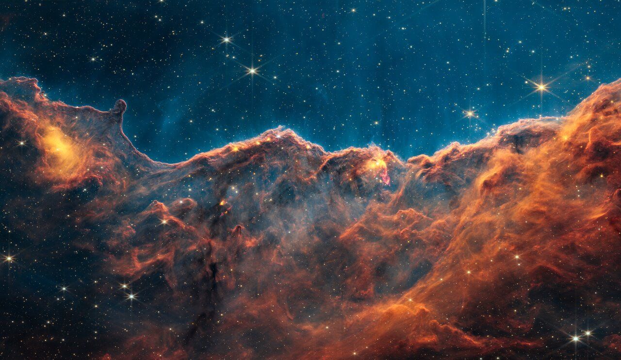 Nebula with fiery orange and brown clouds against a starry blue background.