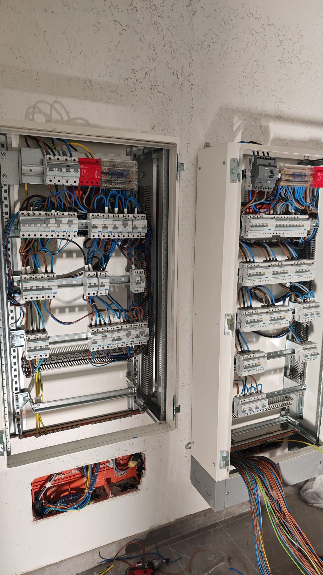 Quadri elettrici aperti con cablaggi, interruttori automatici e morsettiere all’interno di un locale tecnico.