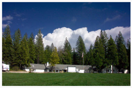 A house in the middle of a field with trees in the background