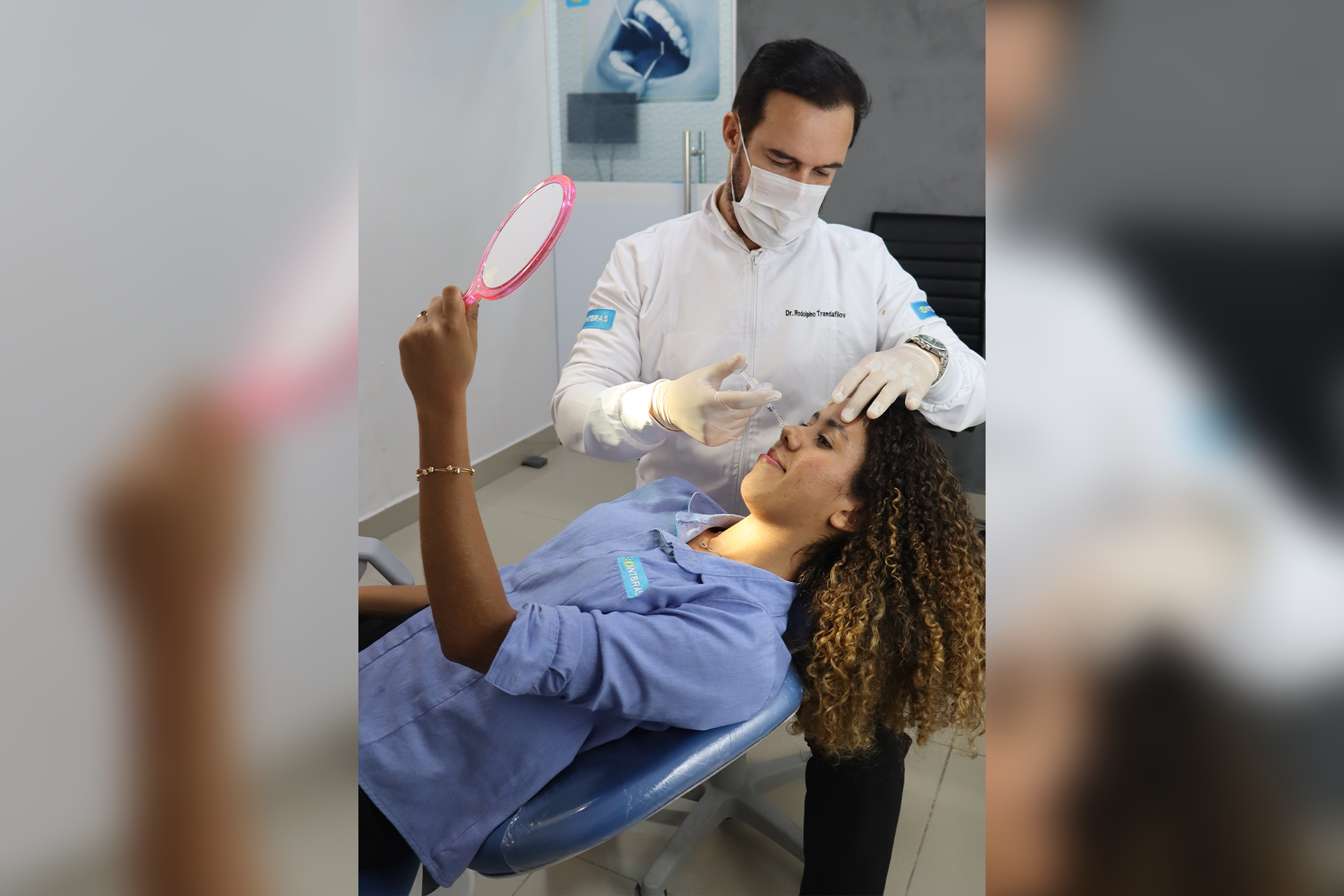 Dentista examinando um paciente sentado em uma cadeira, segurando um espelho em uma clínica.
