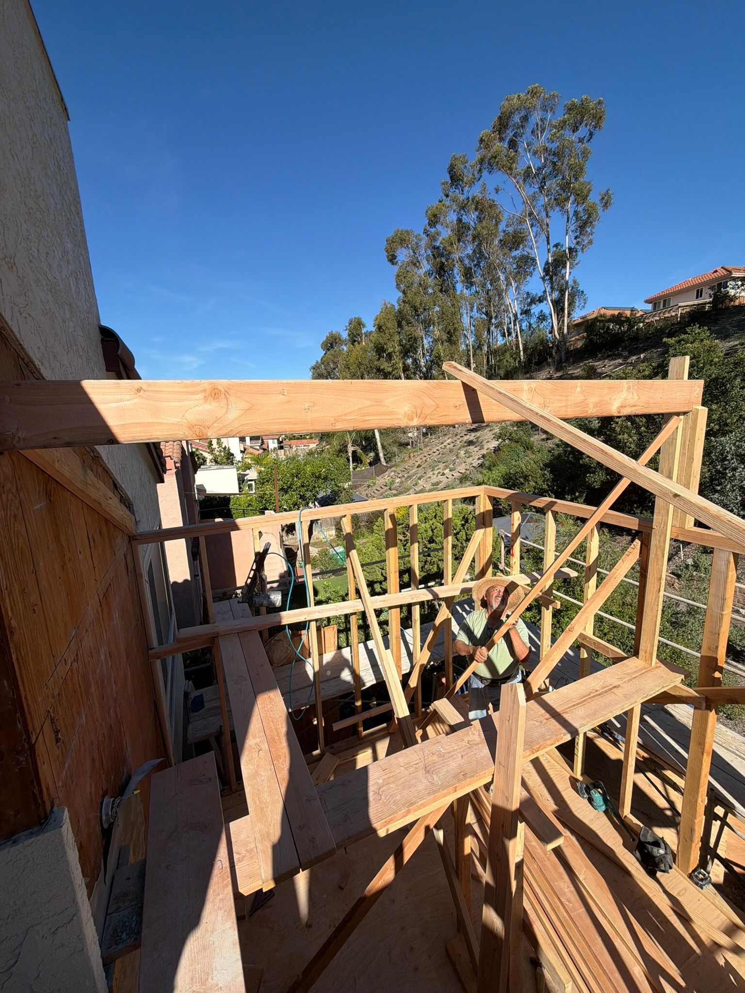 Wooden construction framing on a balcony or patio under a clear blue sky