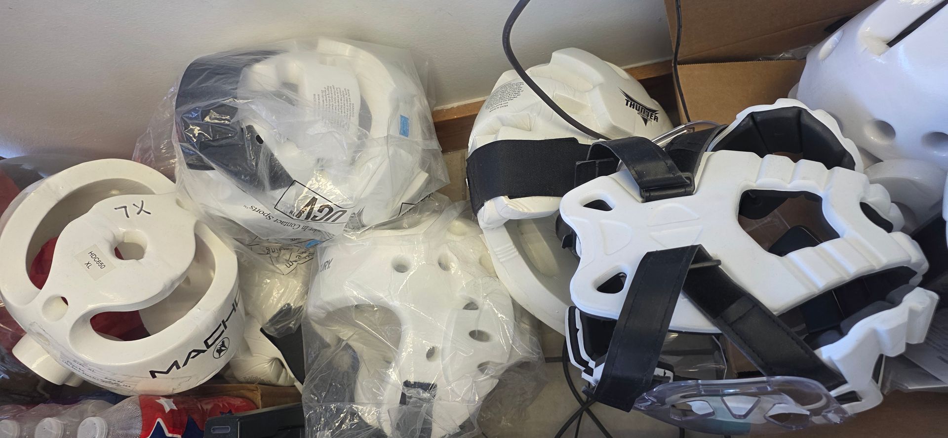 Assorted white and black plastic masks and face pieces piled in a box
