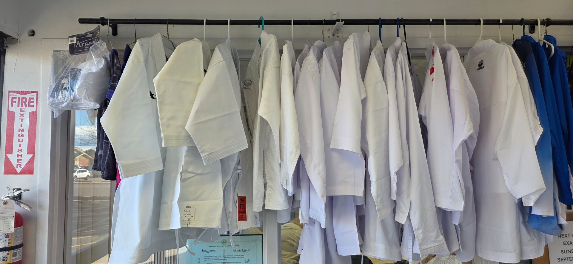 White lab coats and aprons hanging in a row on a rack in a laundry or workroom