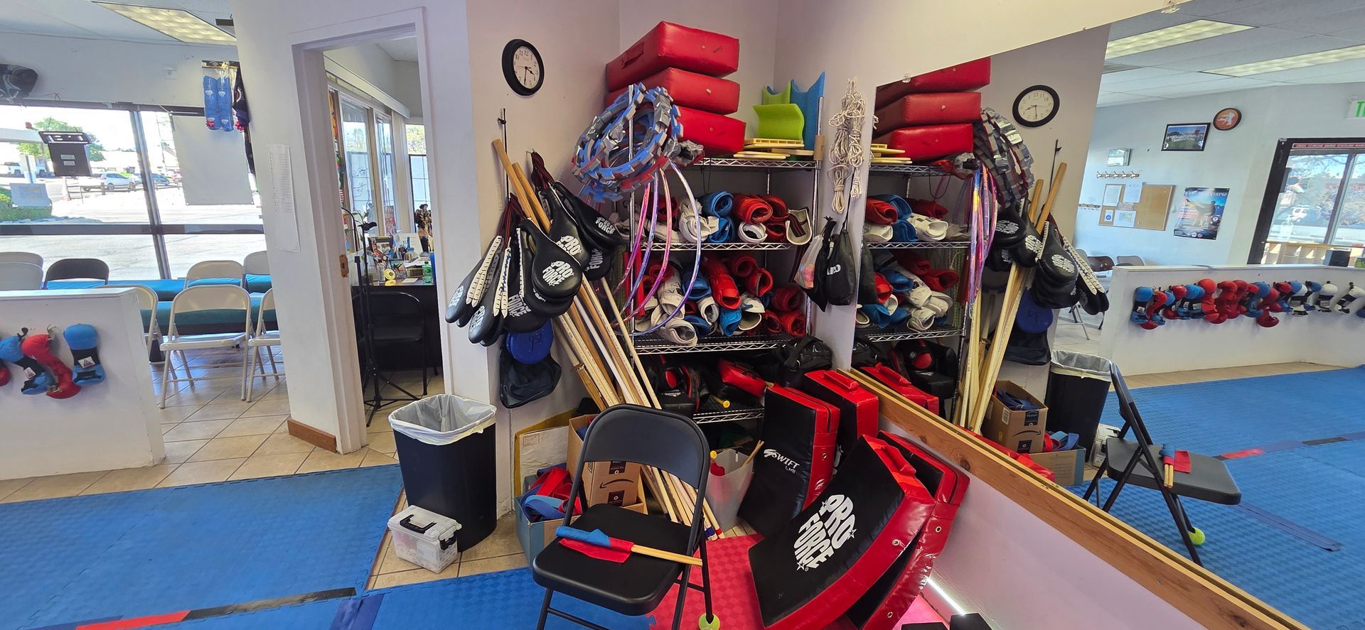 Martial arts training area with red and black pads, gloves, and mirrored walls