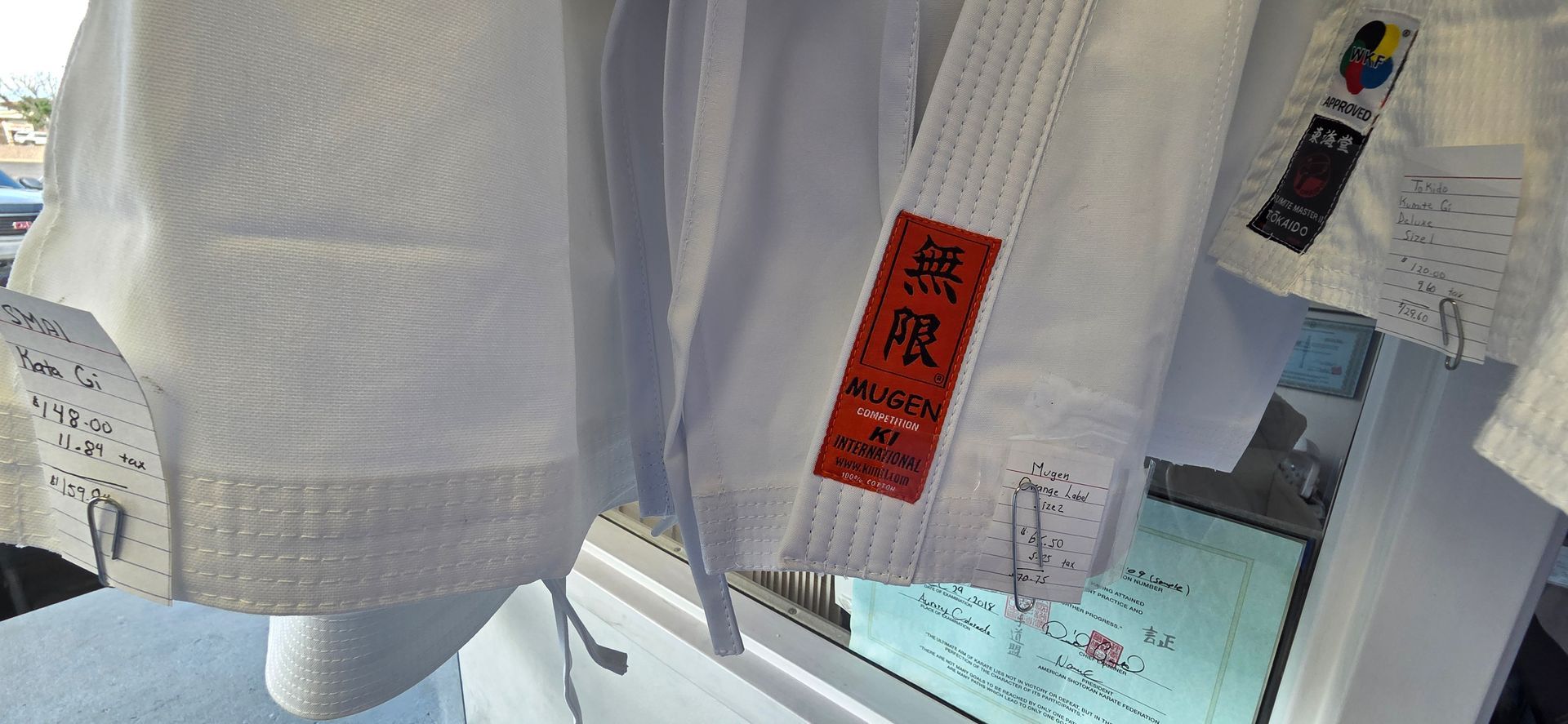 White towels with red labels hanging in a store display by a window