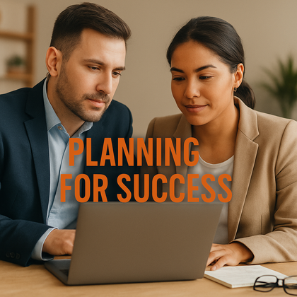 Turning ideas into actionable goals. Man in a suit talking with a woman in a suite with a laptop in front of them. With the words Planning for Success over the image.