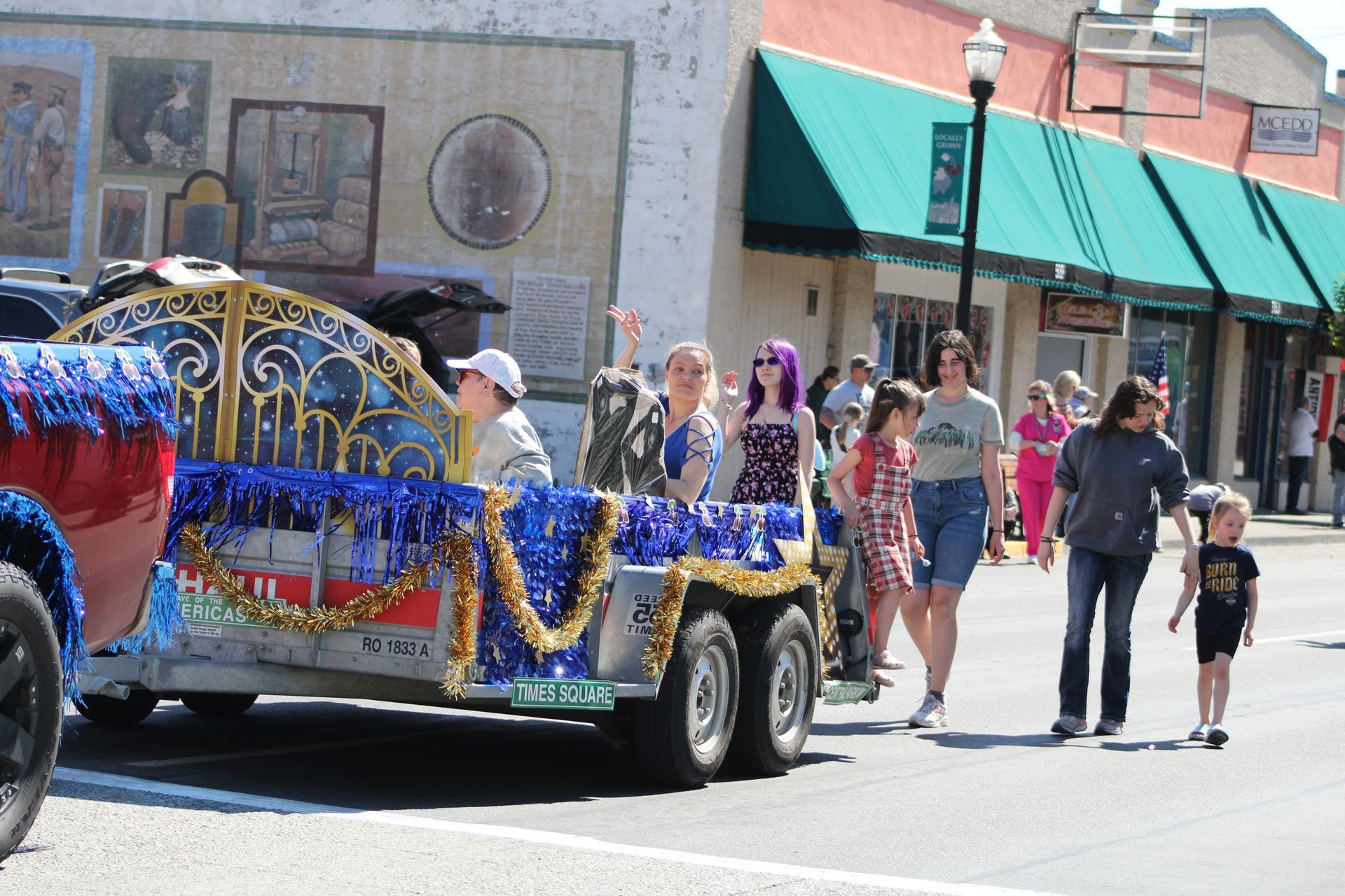 A group of people are walking down a street in front of a parade float.