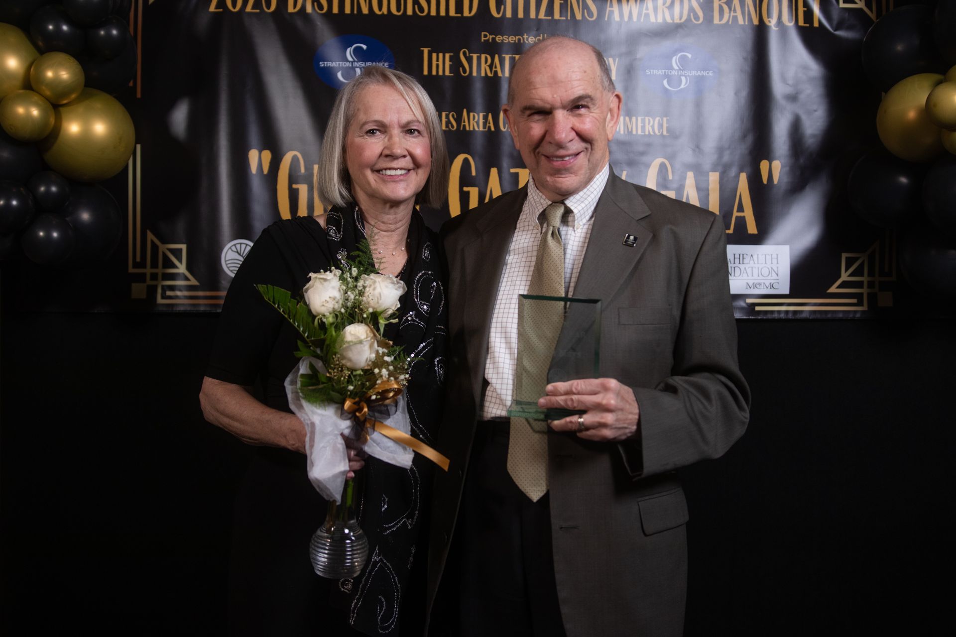 A man and a woman are posing for a picture at a gala.