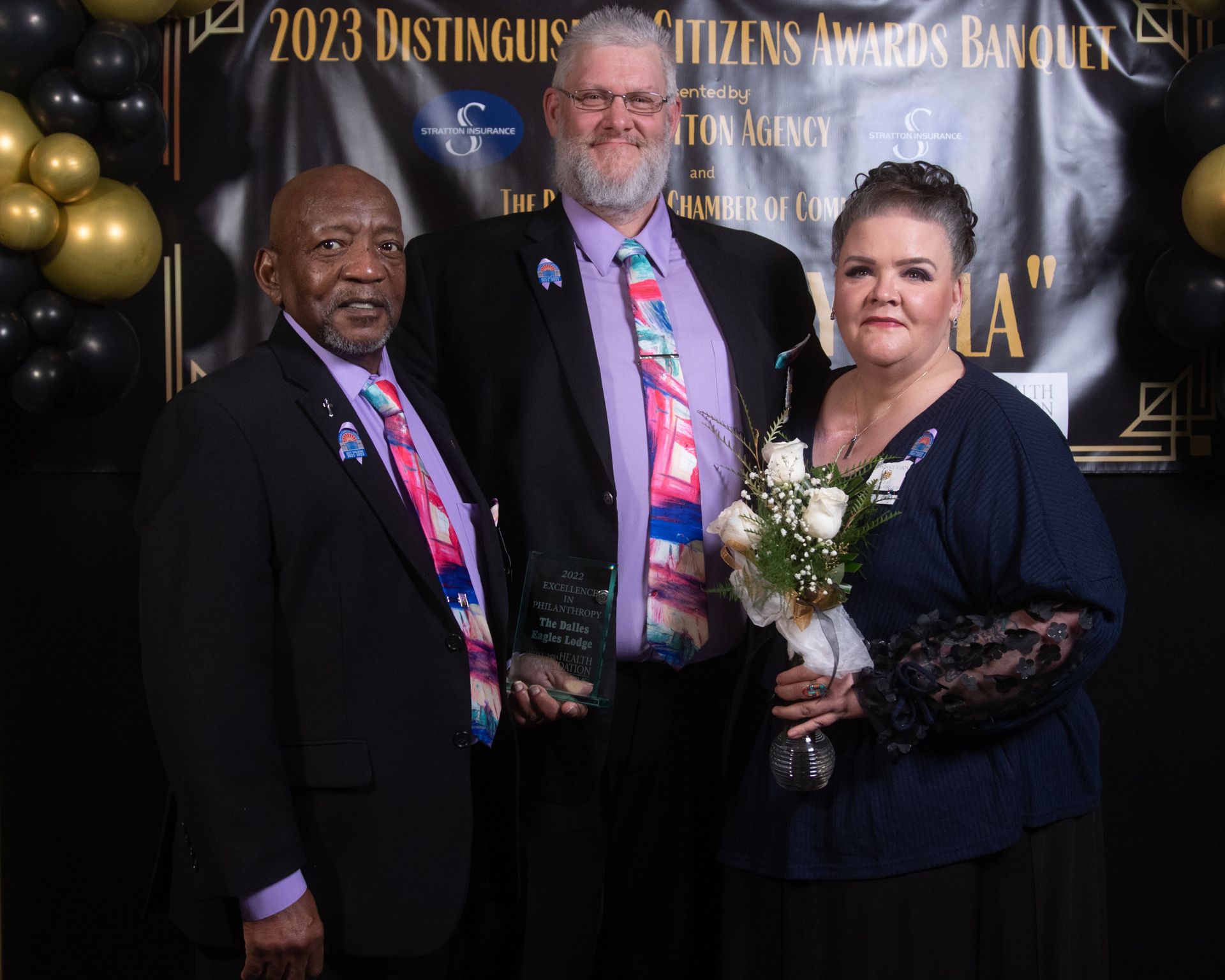 Three people are posing for a picture in front of a sign that says 2023 destinguis citizens awards banquet