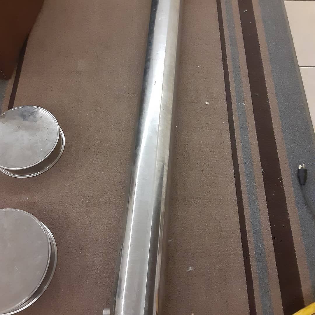 A metal pipe is sitting on top of a striped rug