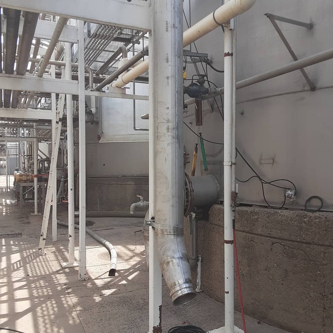 A large pipe is hanging from the side of a building