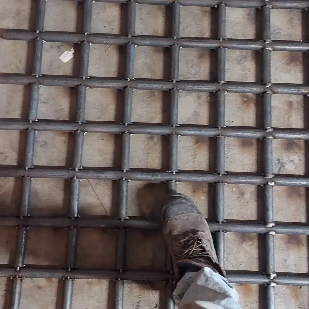 A person 's foot is standing on a metal grid