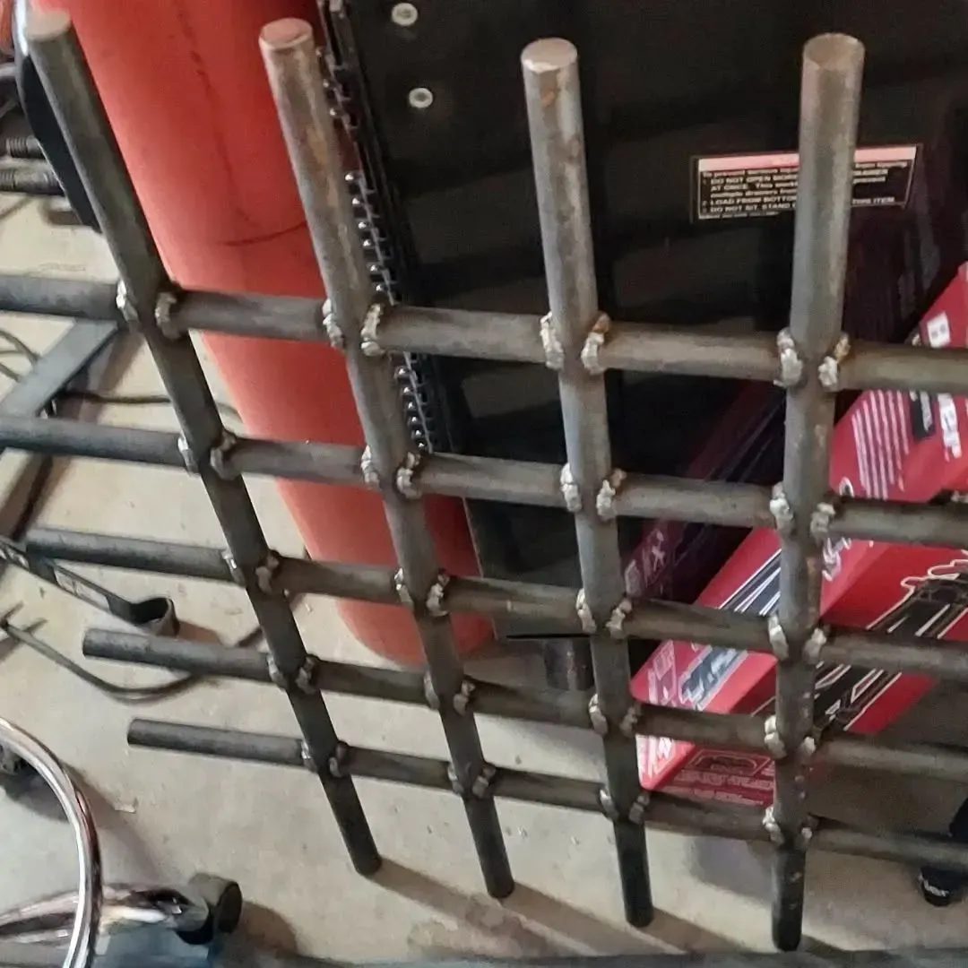 A metal fence with a red barrel in the background