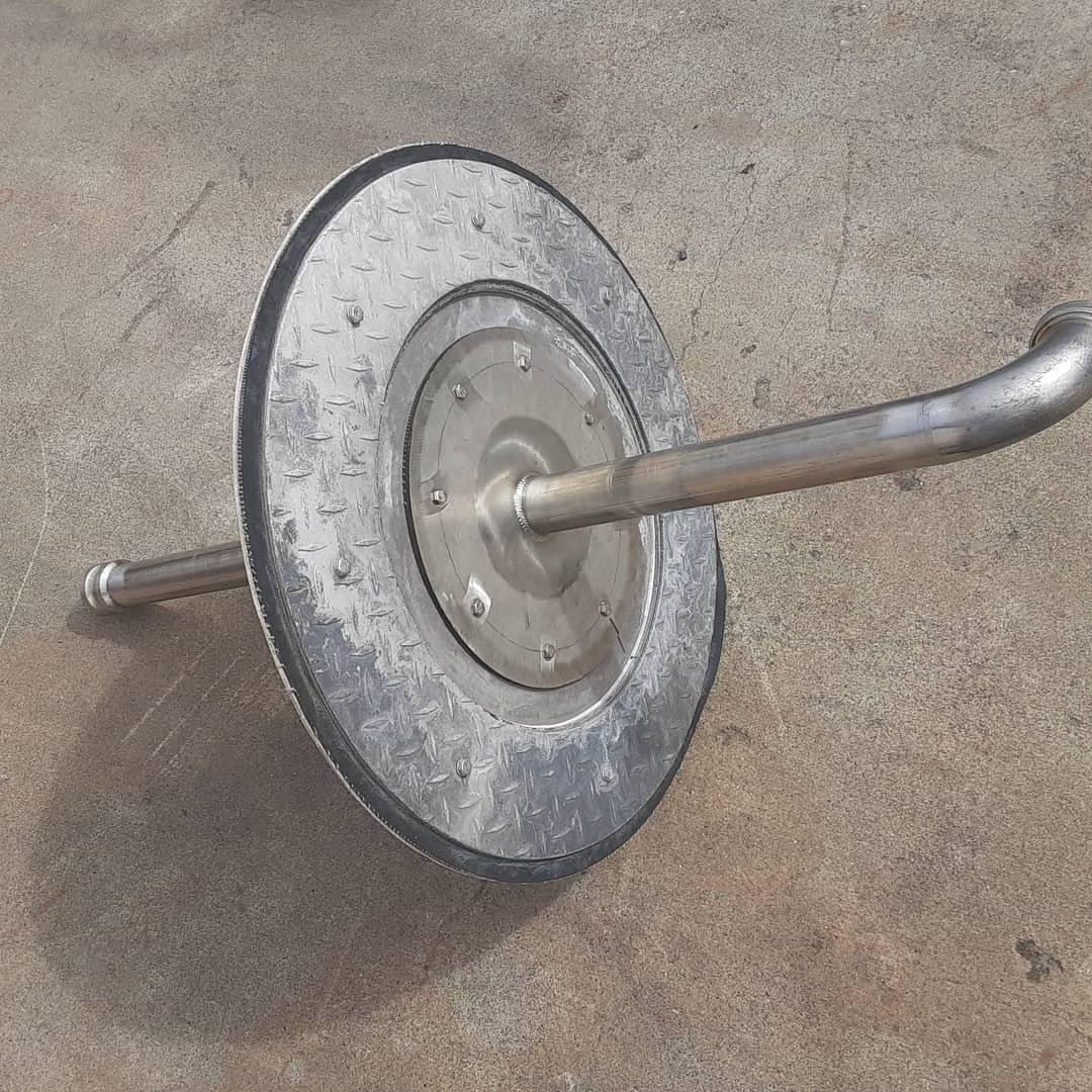 A metal object is sitting on a concrete surface.