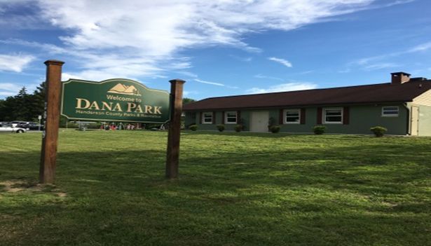 A sign for dana park is in front of a house.