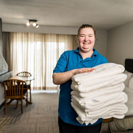 ahs hospitality housekeeper holding clean white towels