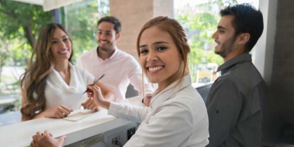Hotel workers assisting hotel guests at hotel reception 