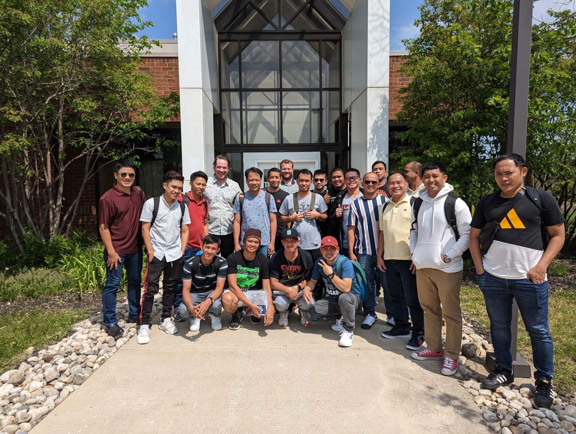 A group of young men are posing for a picture in front of a building.