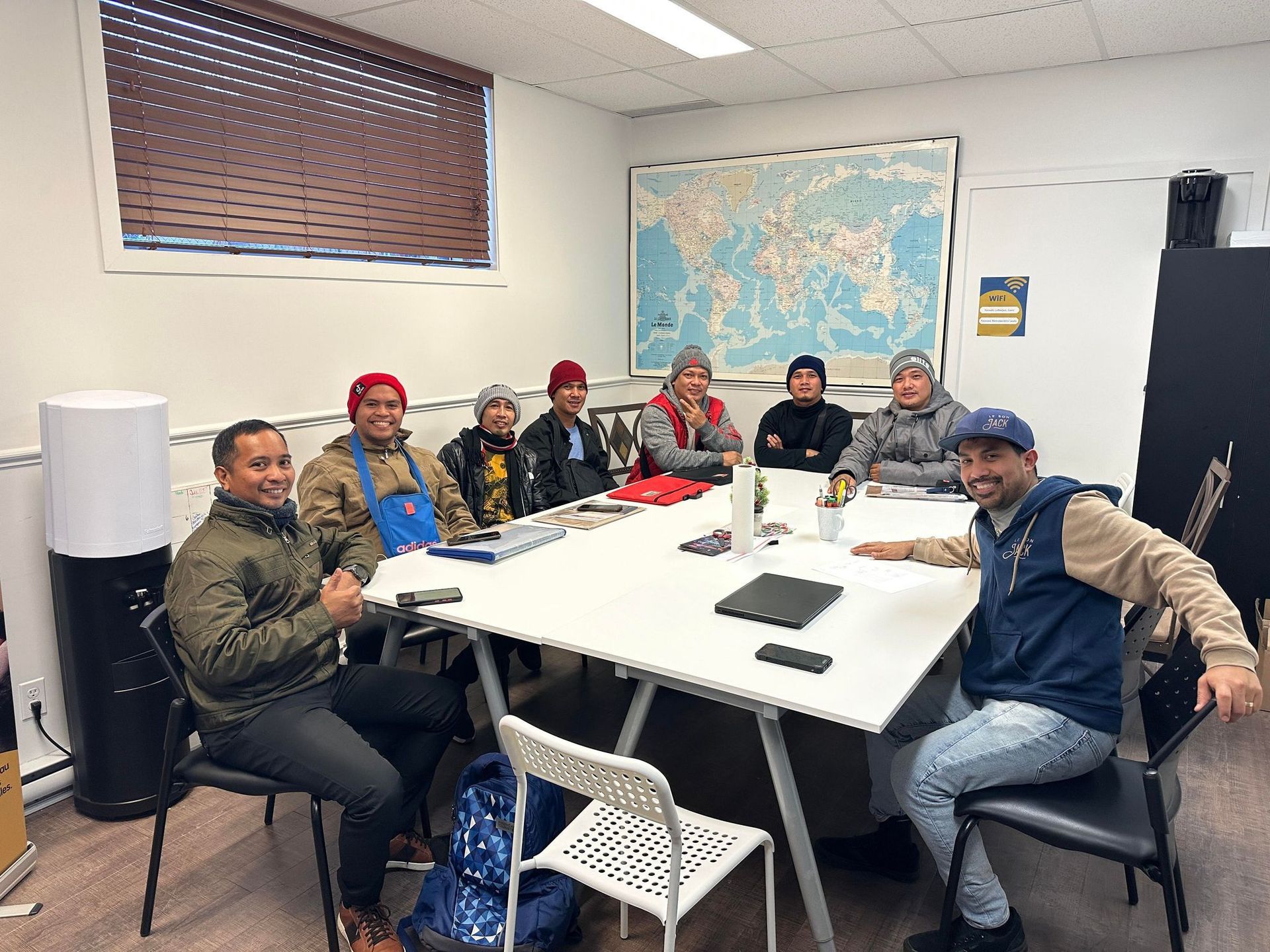 A group of people are sitting around a table in a room.