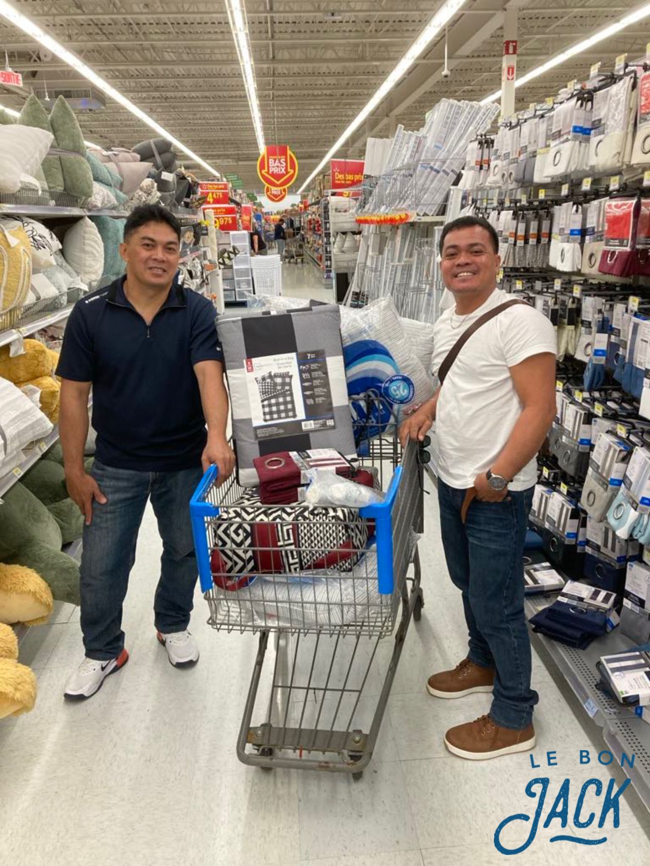 Two men are standing next to a shopping cart in a store.