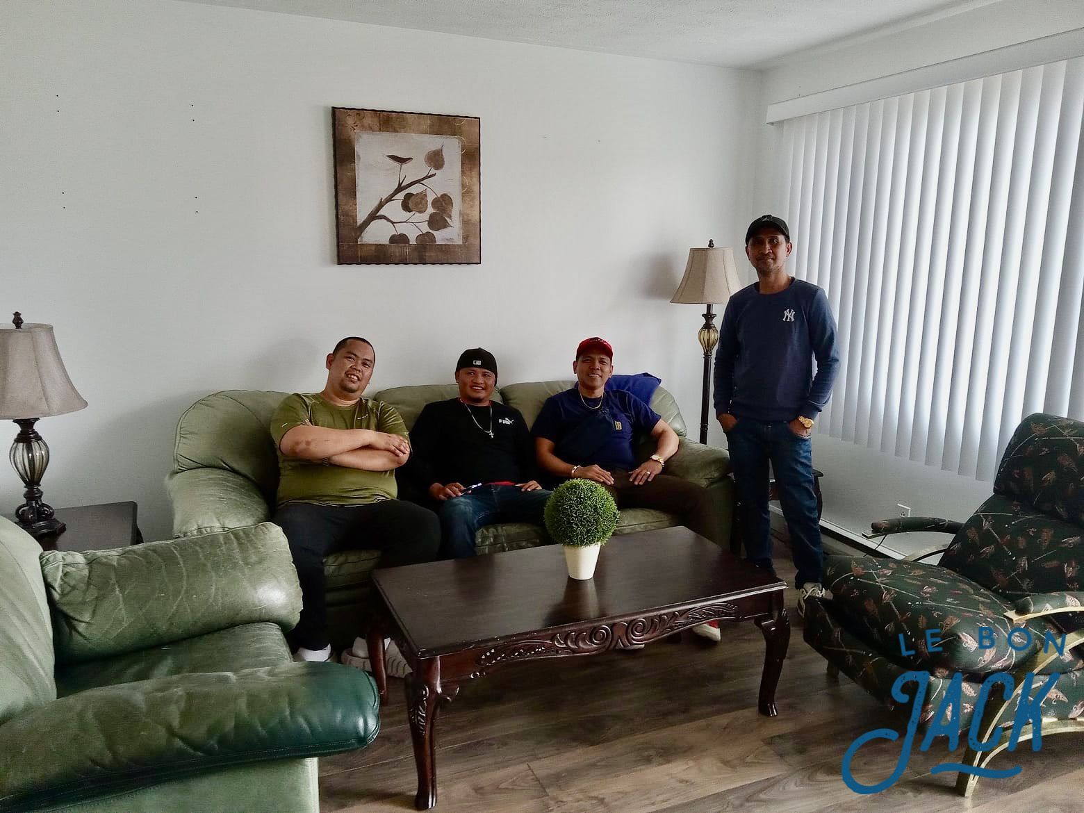 A group of men are sitting on a couch in a living room.
