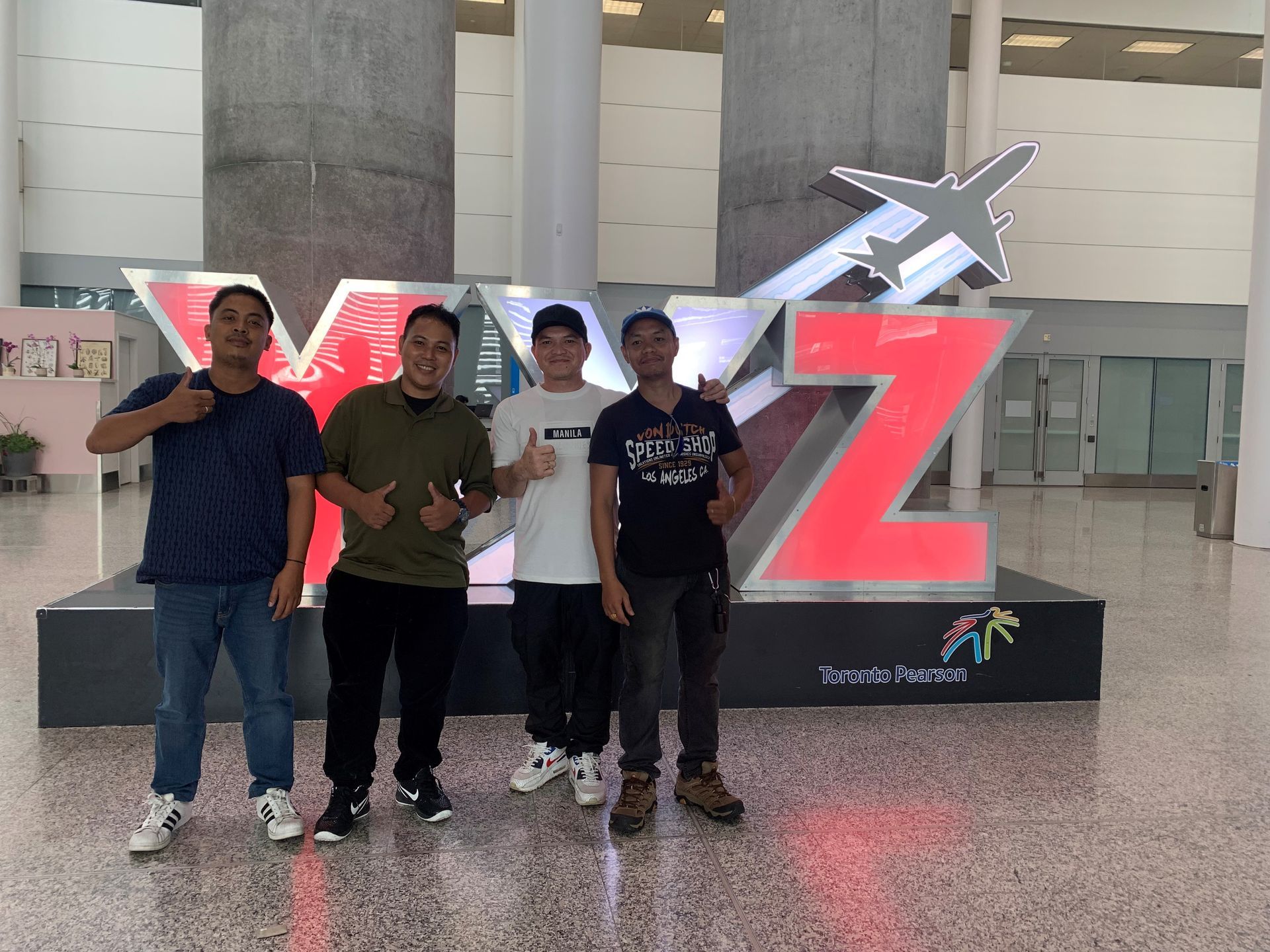 A group of men are posing for a picture in front of a large y and z sign.