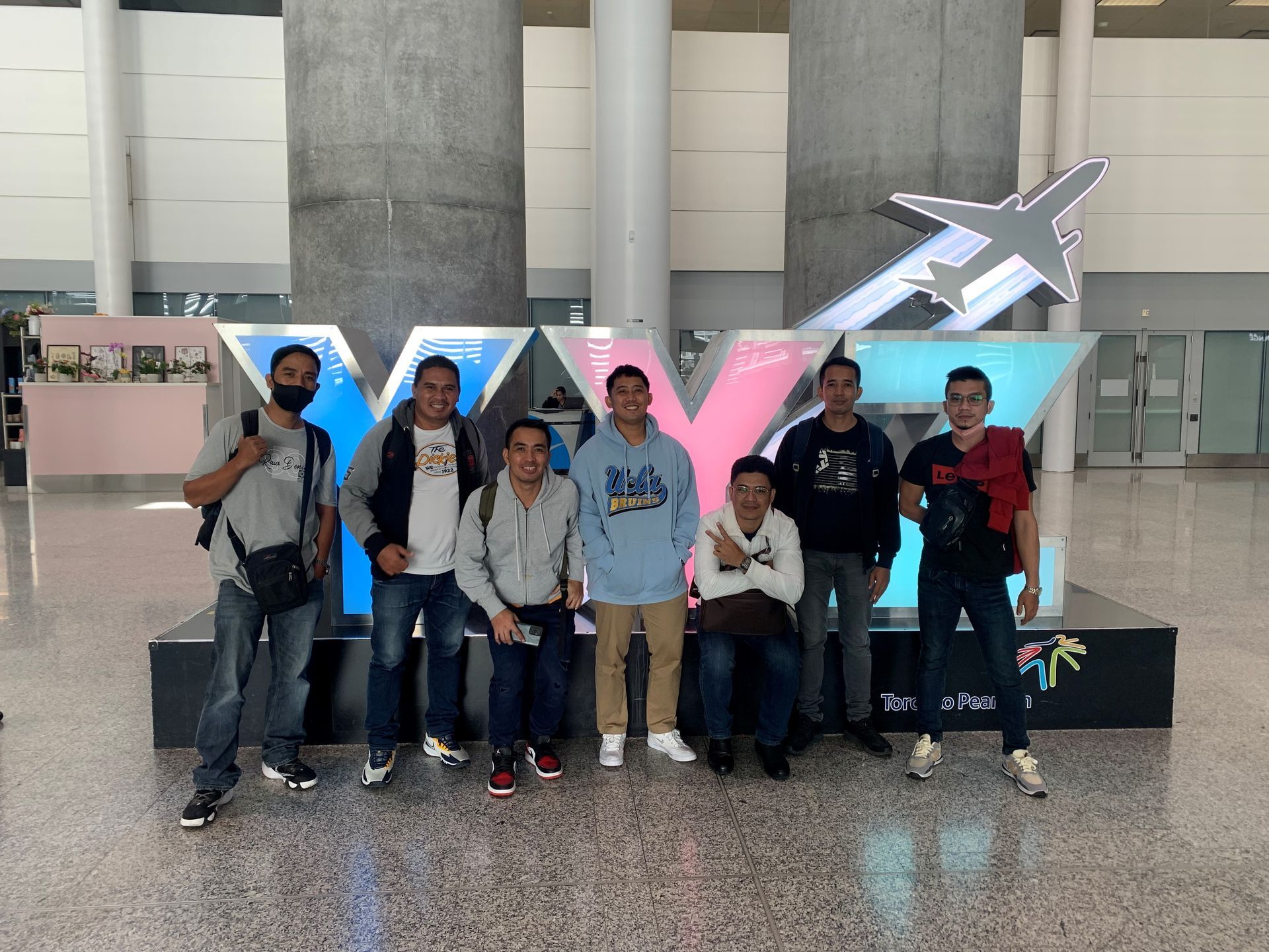 A group of men are posing for a picture in front of a sign that says xyz