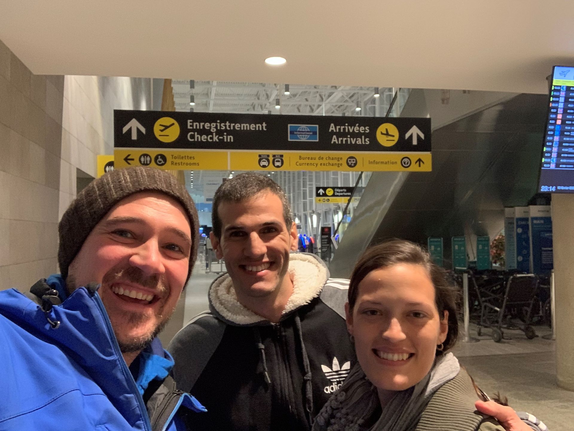 A group of people are posing for a picture at an airport.