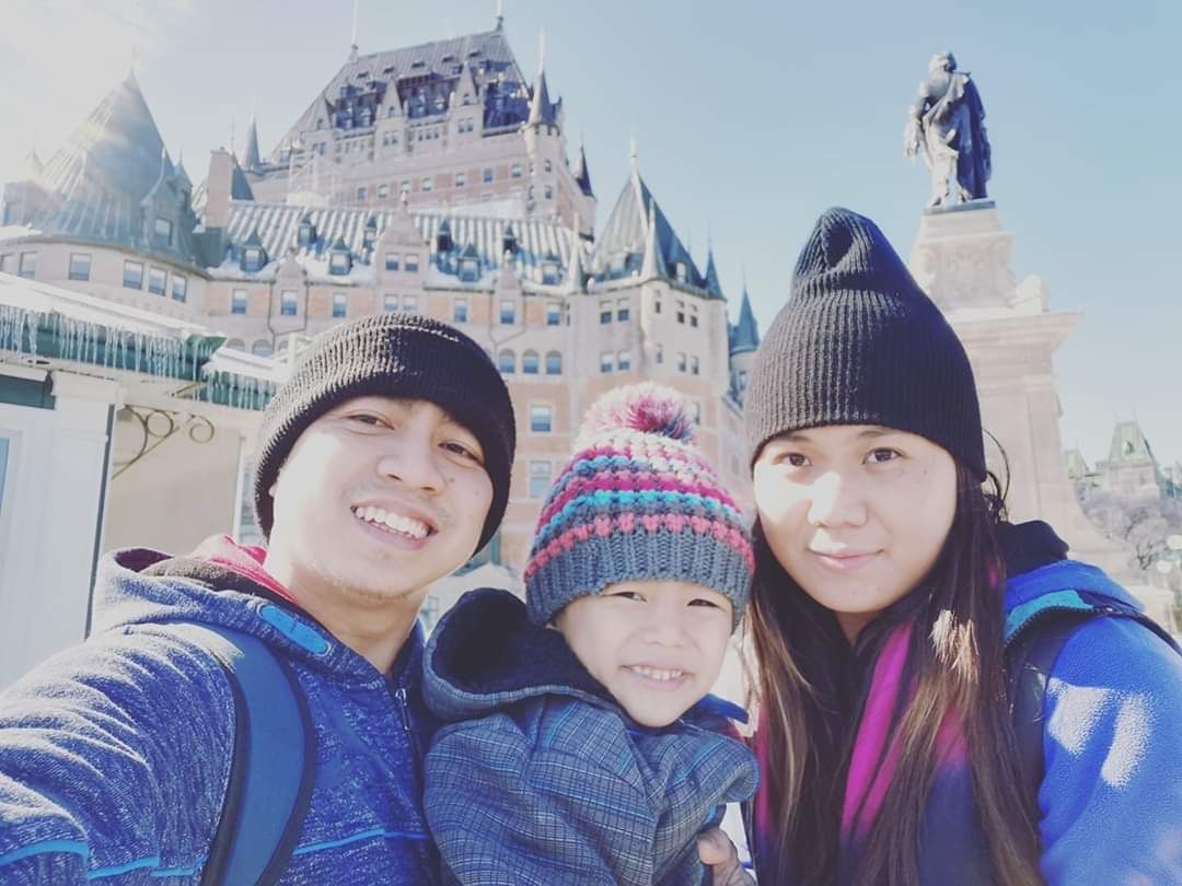 A family is posing for a picture in front of a castle.