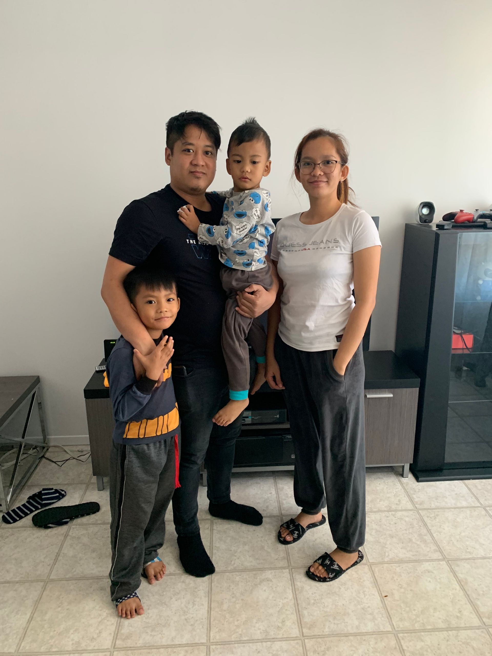 A family is posing for a picture in a living room.