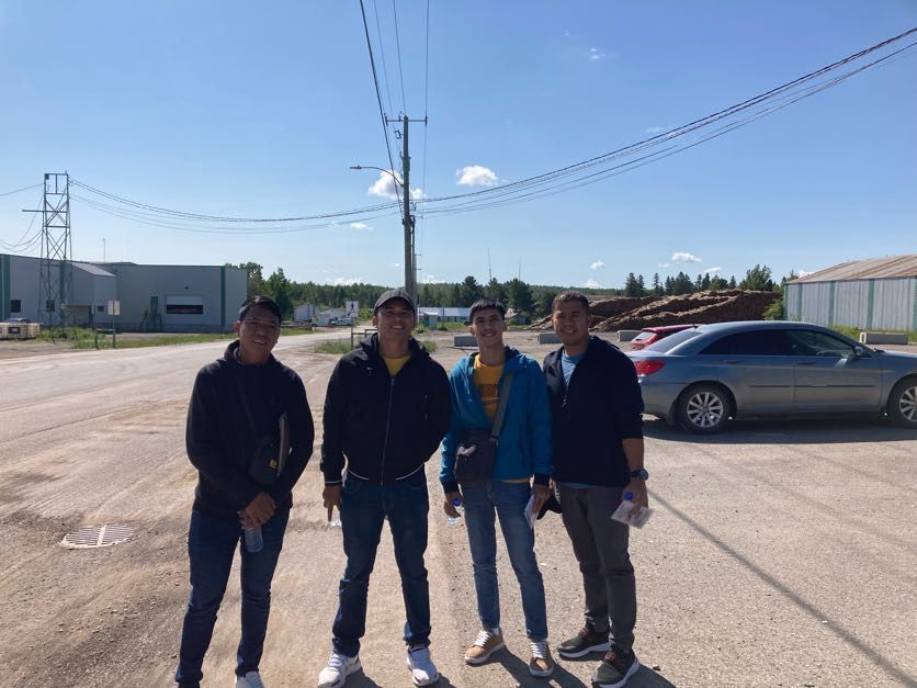 A group of young men are standing next to each other in a parking lot.