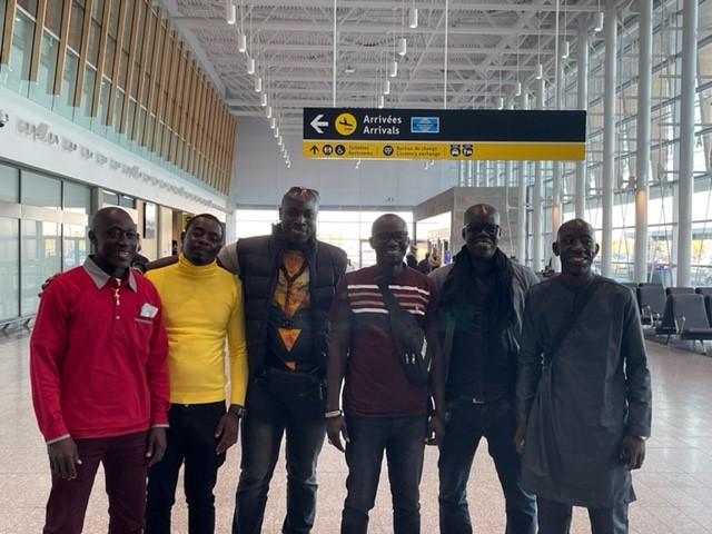 A group of men are posing for a picture in an airport