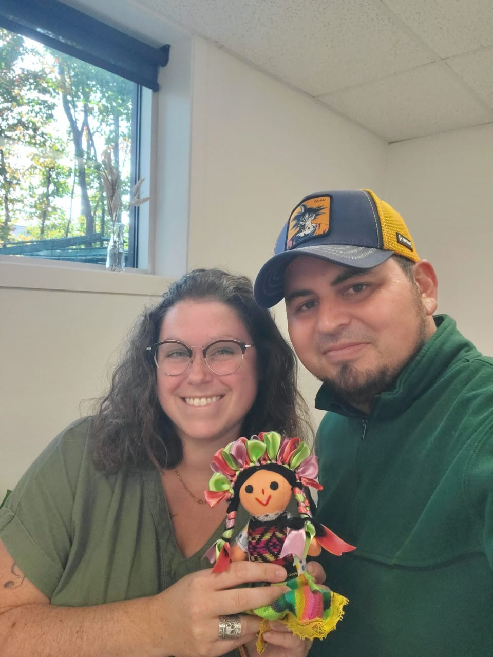 A man and a woman are holding a stuffed doll