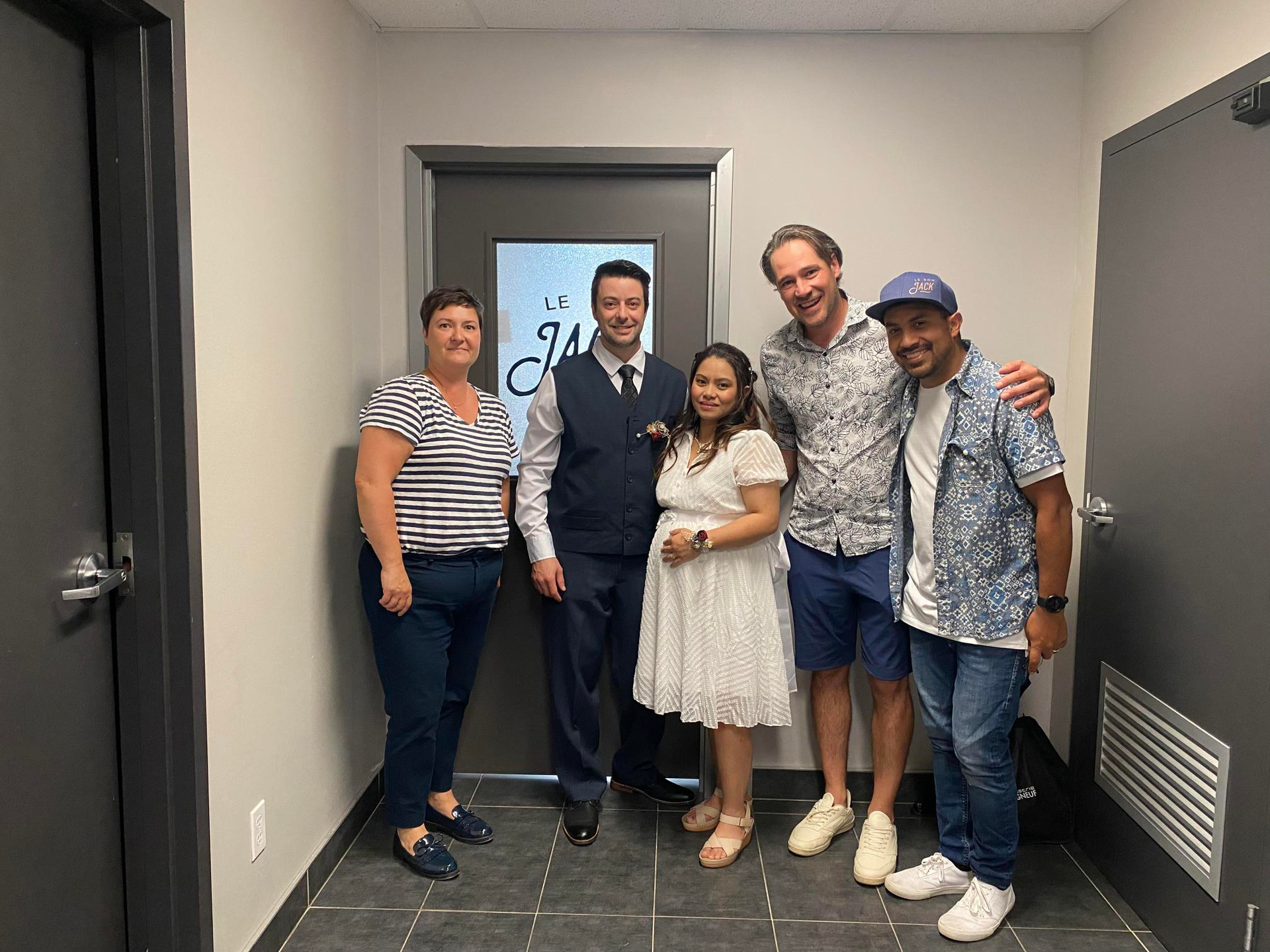 A group of people are posing for a picture in a hallway.