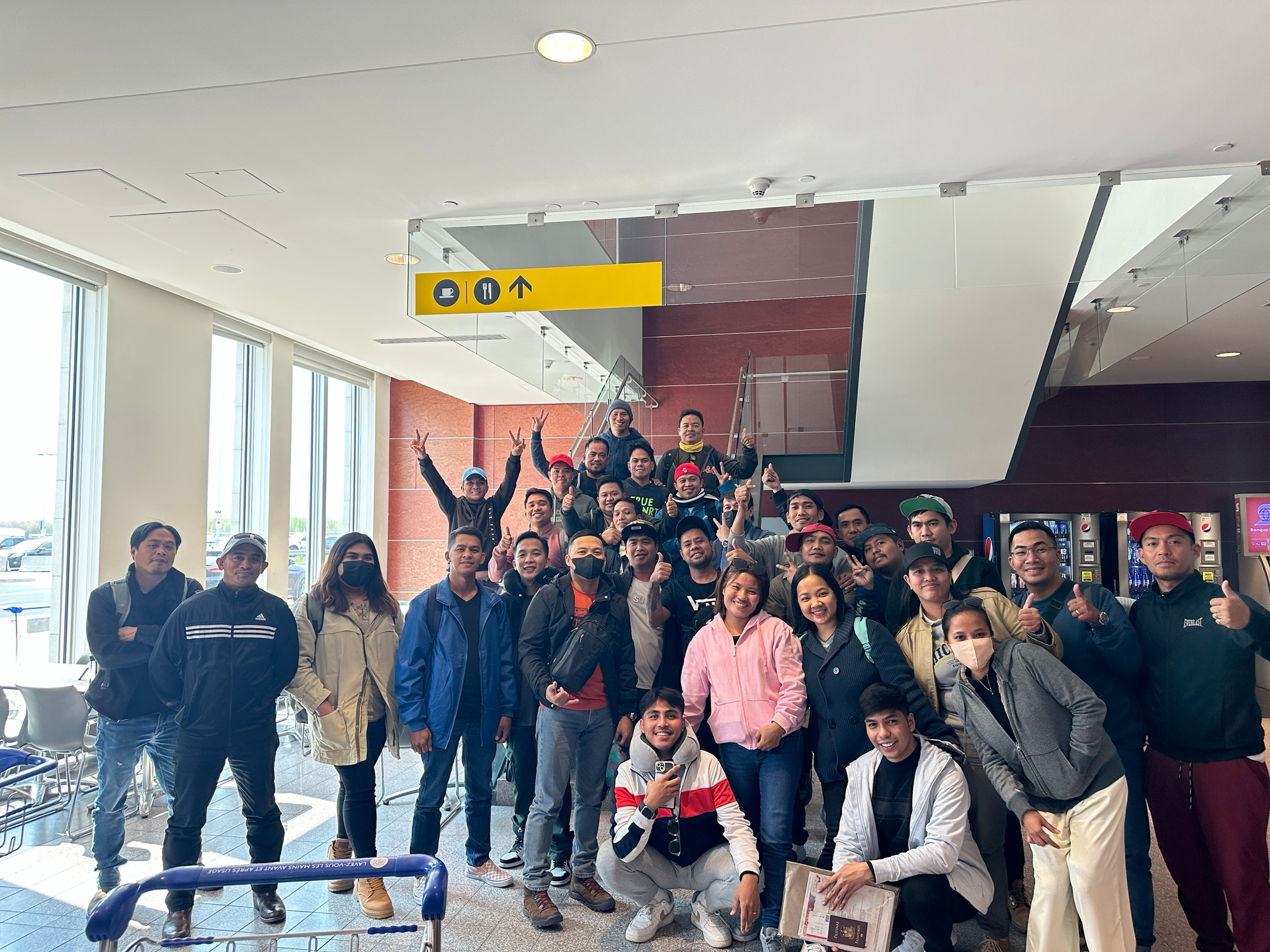 A group of people are posing for a picture in an airport.